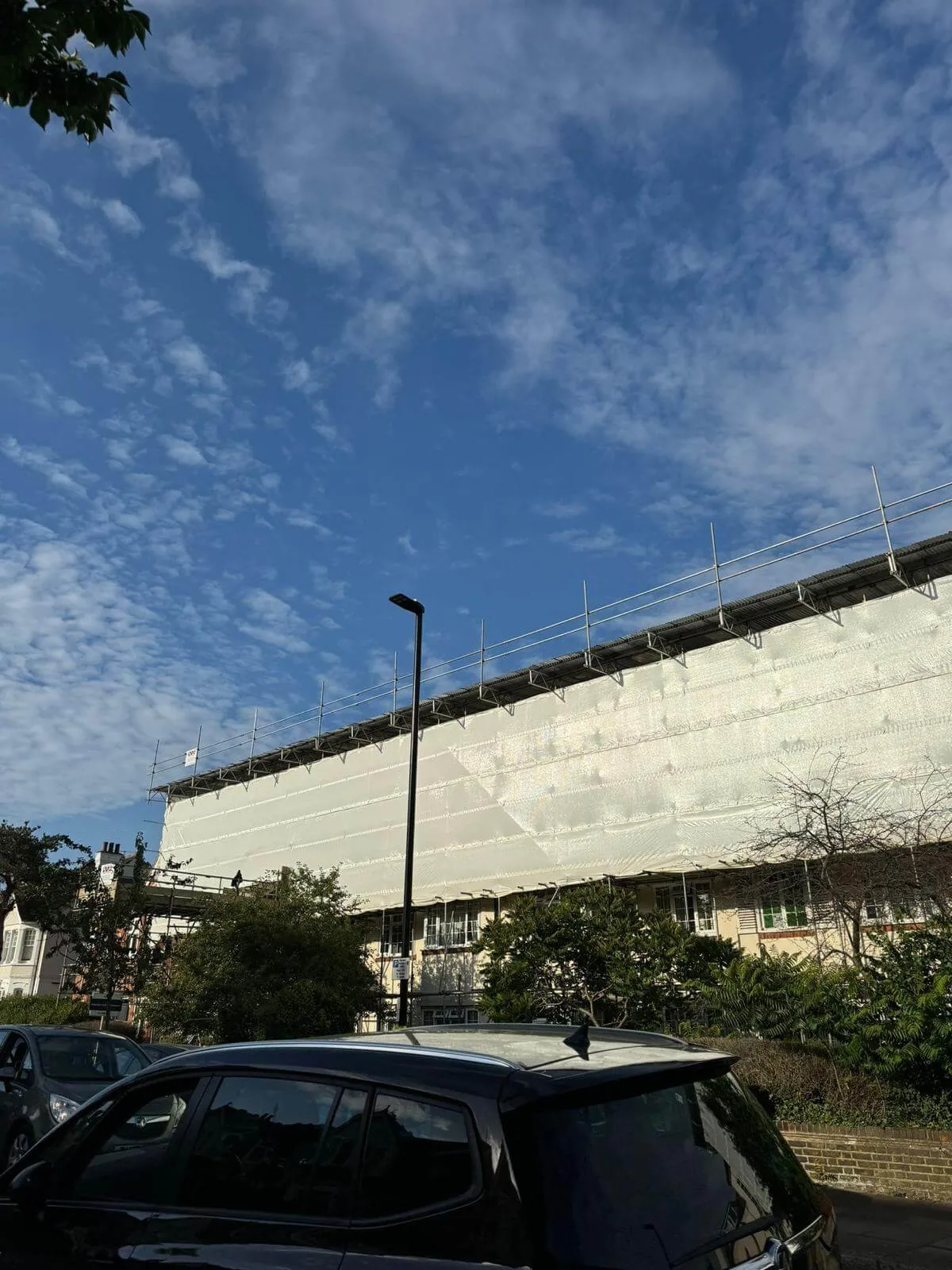 Fully sheeted temporary roof scaffolding protecting a building during a roof strip
